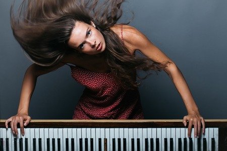 63549147-jeune-fille-ou-femme-avec-joli-visage-et-cheveux-longs-brune-a-corps-sexy-posant-près-de-vieux-piano.jpg